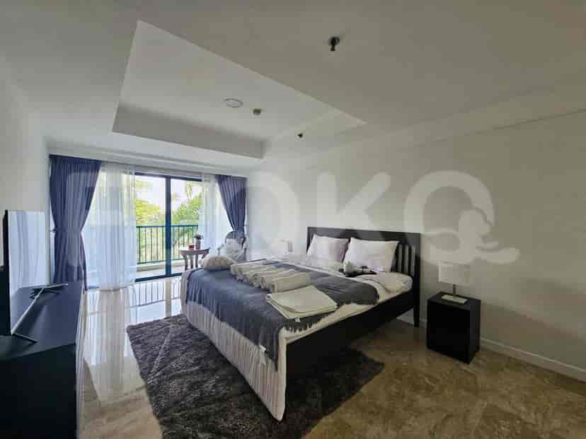 Modern bedroom with a large bed, dark furniture, and access to a balcony.
