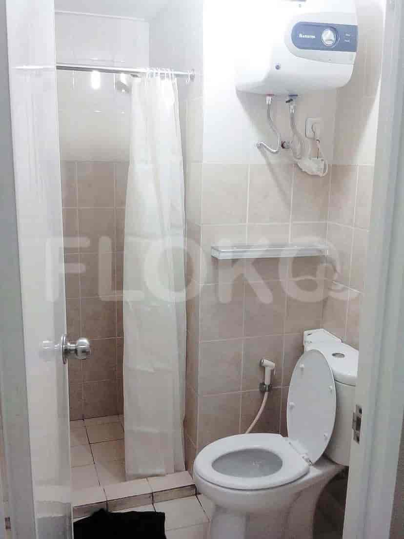 Bathroom with toilet, shower, and water heater.