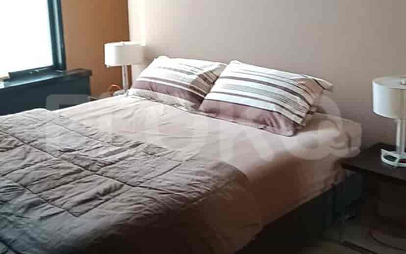 A cozy bedroom featuring a double bed, bedside lamps, and a neutral color palette.