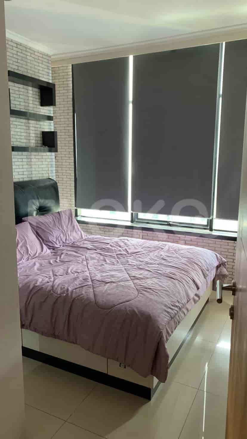 A modern bedroom with a bed, large window, and brick-patterned accent wall.