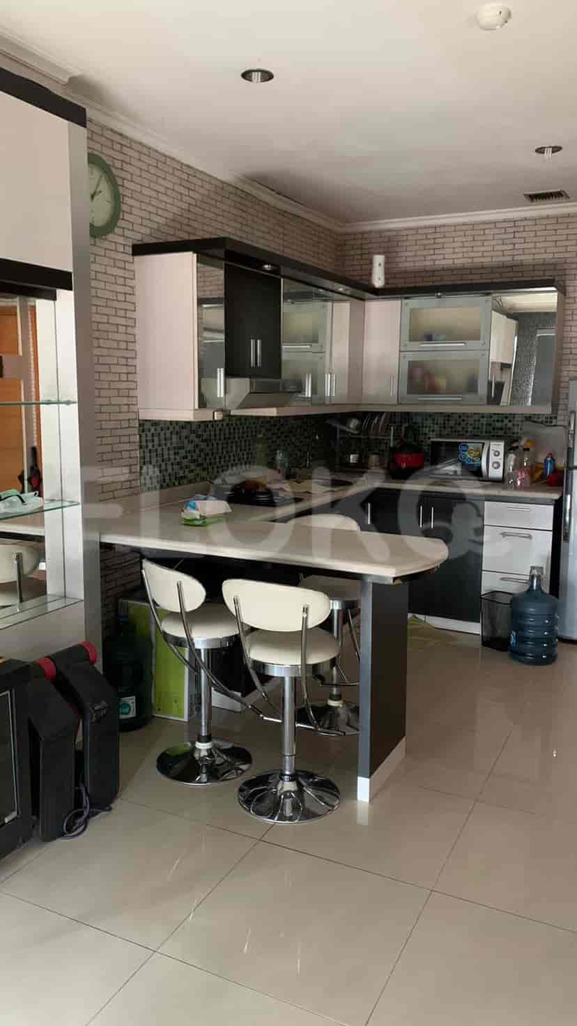 A well-equipped kitchen with a bar counter and two stools.