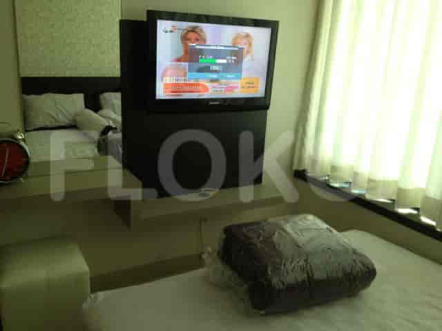 Kamar tidur dengan TV yang dipasang di dinding dan tempat tidur.