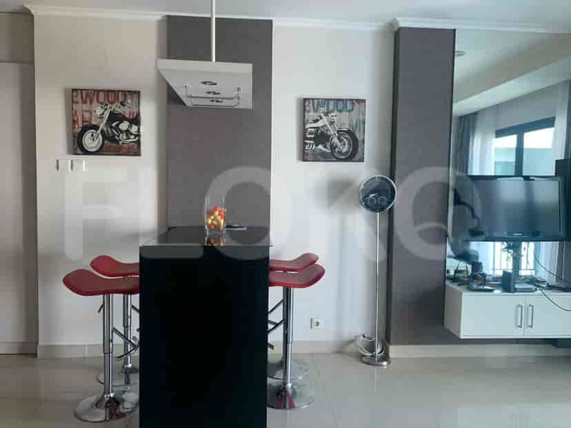 Dapur modern dengan bar dan kursi tinggi, dilengkapi dengan seni.