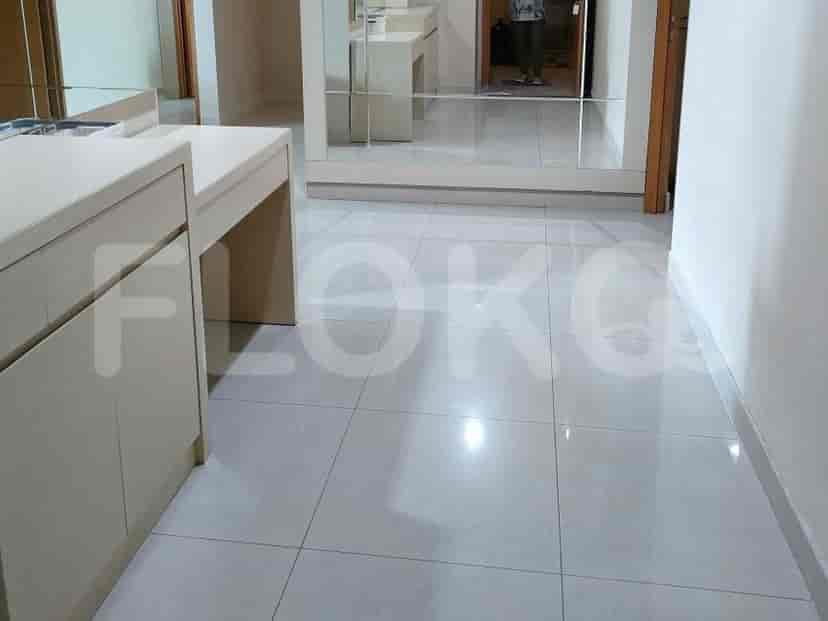 A hallway with white cabinets and mirror