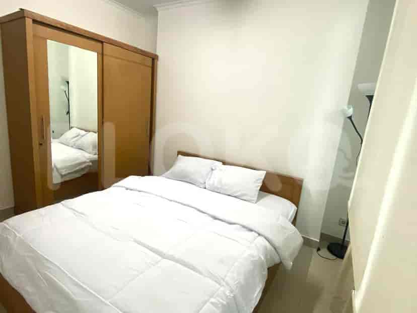 A bedroom with a double bed, wooden wardrobe with mirror.