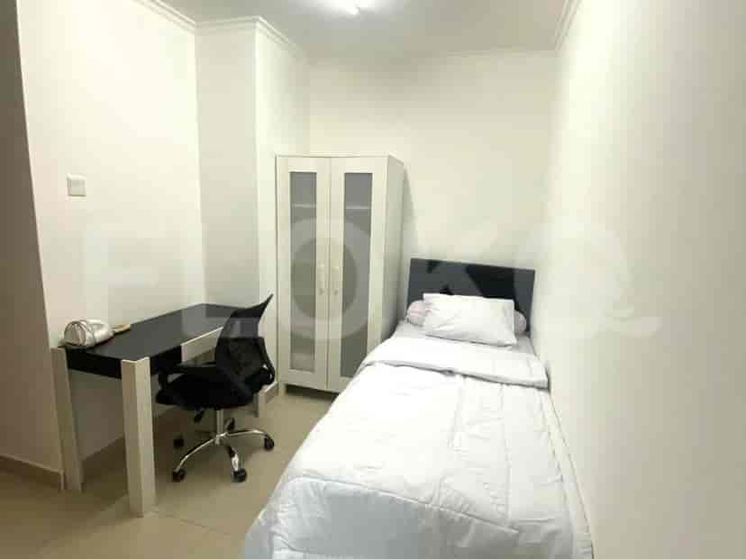 A single bed room with desk and wardrobe.