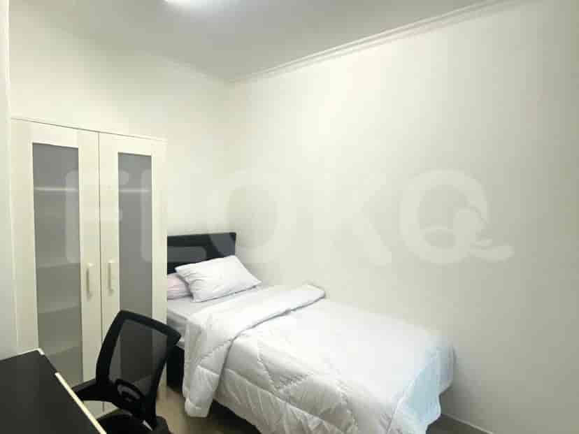 A small bedroom with single bed and desk.