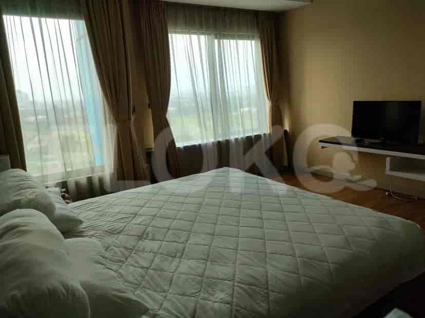 Bedroom with a queen bed and large windows.