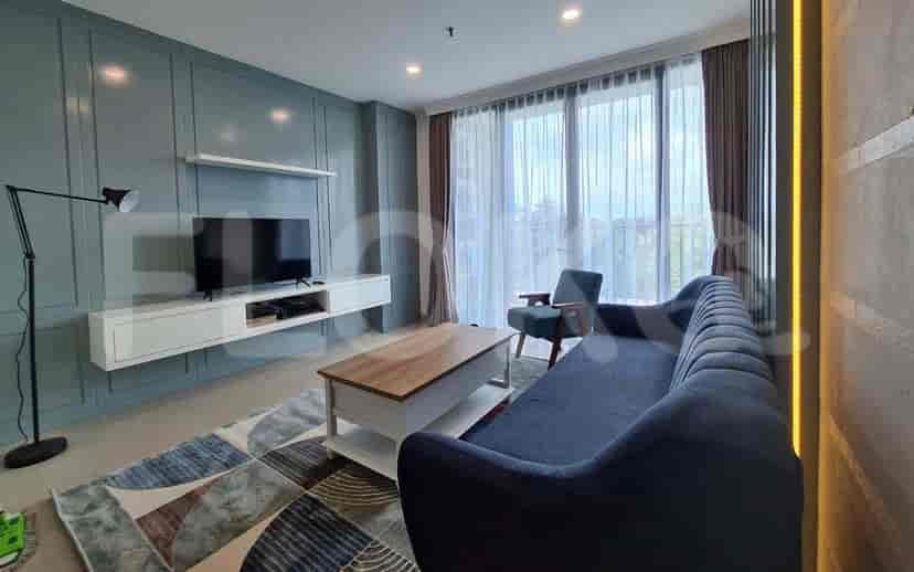 Modern living room with blue wall paneling, a grey sofa, and a coffee table.