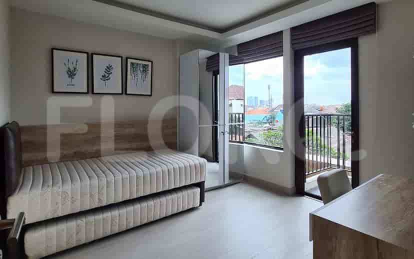 Small bedroom area with a sofa bed, and a balcony.