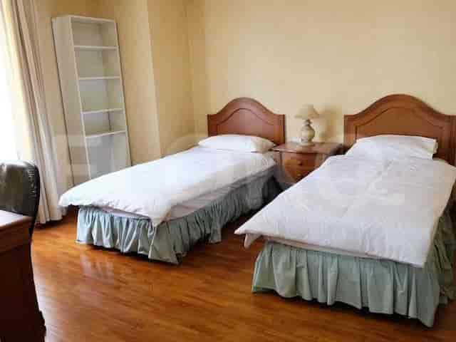 Bedroom with twin beds, nightstands, and wooden flooring.