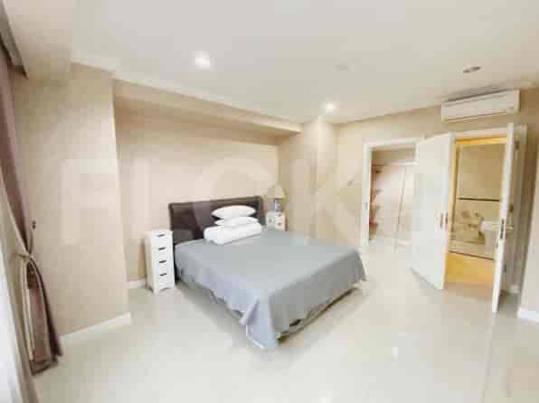 A bedroom with a bed, nightstands, and a large closet.