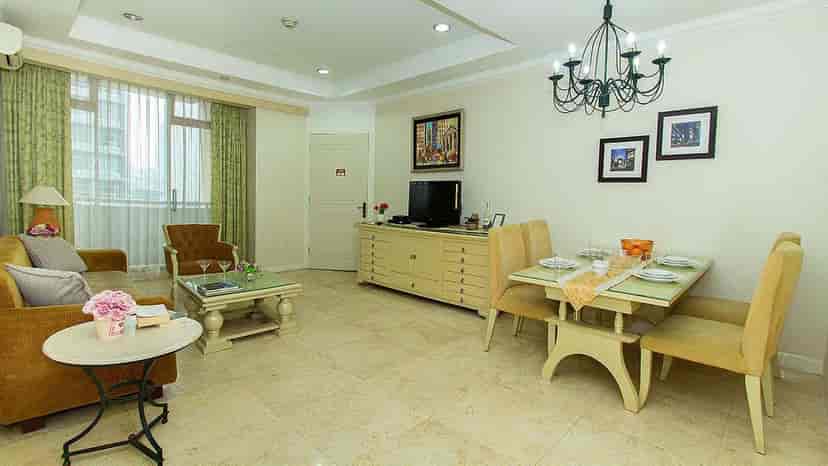 Spacious living and dining area with beige furnishings and city views.