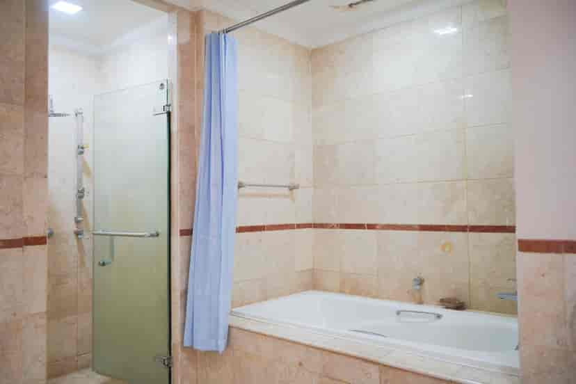 Kamar mandi dengan bak mandi dan area pancuran.
