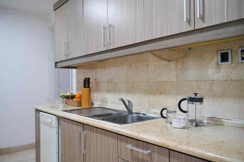 Dapur dengan lemari, wastafel, dan kompor.
