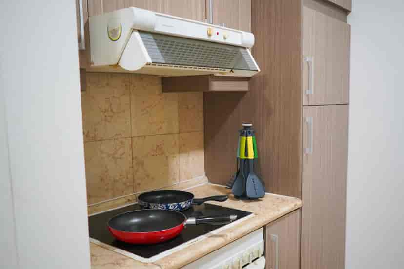 Dapur dengan kompor, tudung range, dan lemari.