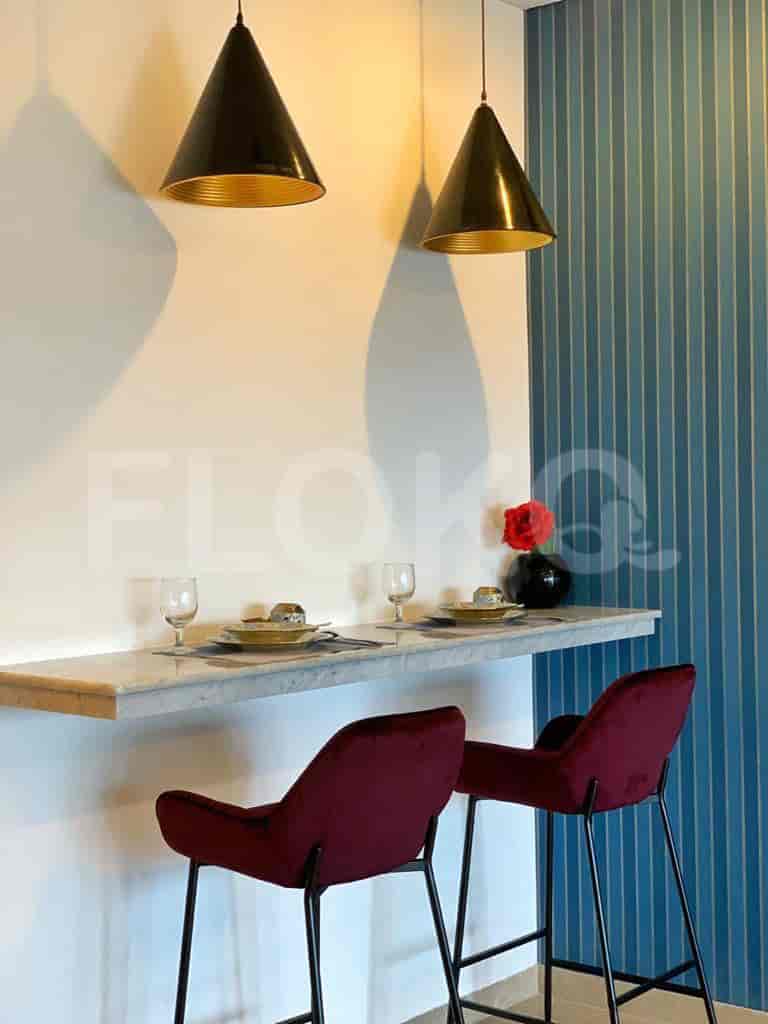 A closer view of a breakfast bar with stools and pendant lights.