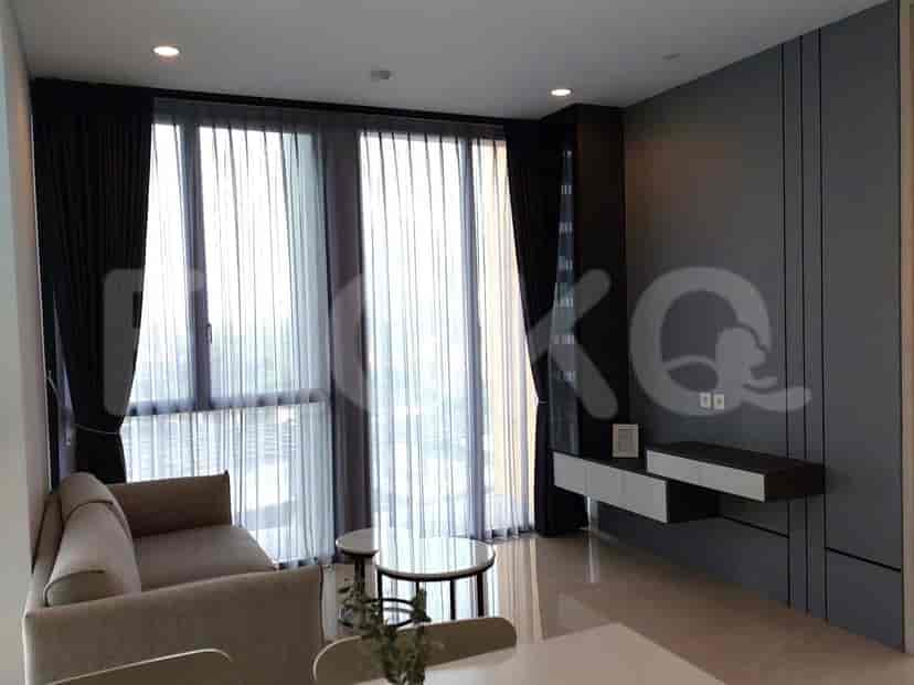 Ruang tamu modern dengan sofa, meja kopi, dan jendela besar dengan gorden tipis.