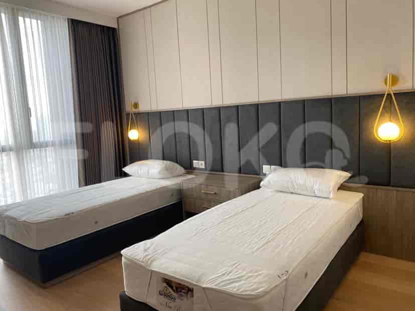 A bedroom with two single beds and a neutral color scheme.