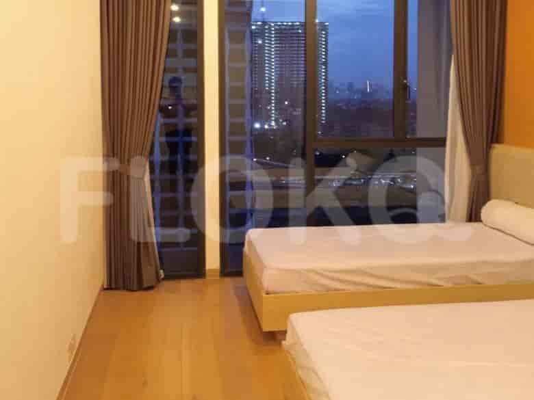Kamar tidur dengan dua tempat tidur single, pemandangan kota, dan dekorasi modern.