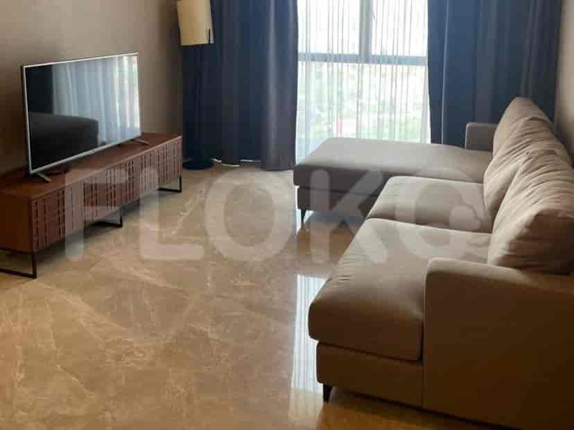 Ruang tamu modern dengan sofa sectional abu-abu, TV di konsol kayu, dan jendela besar.