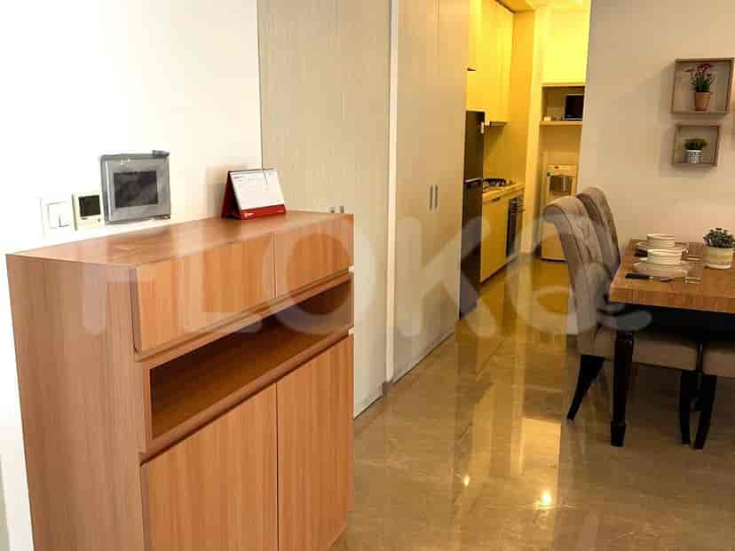 The entryway showcasing a wooden cabinet, with glimpses of the kitchen and dining area in the background.