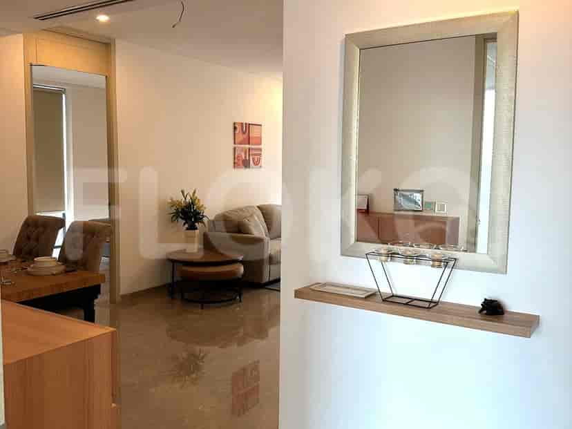 An open living space showing the dining area, a mirror, and a view into the living room.