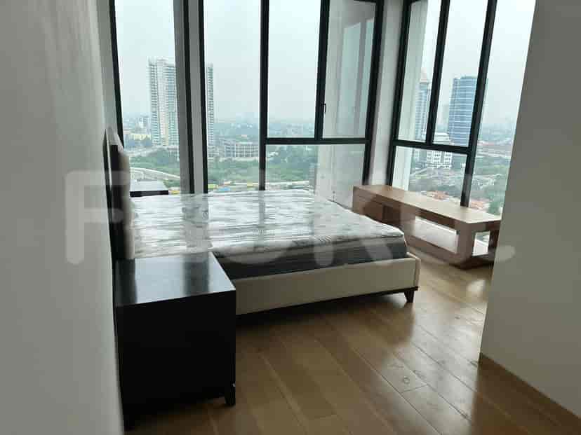 Bedroom with a bed, nightstand, and large window.