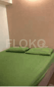 Kamar tidur dengan tempat tidur sprei hijau.