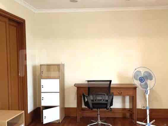 Bedroom with a desk, storage and a fan.