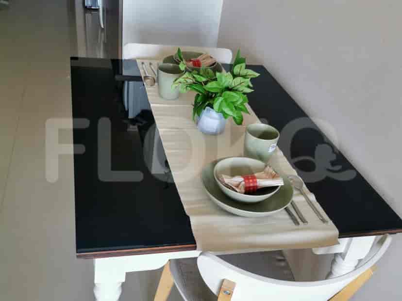 Dining table set for two with decorative items.