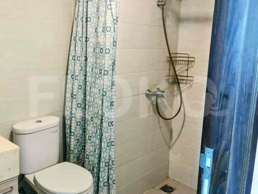 Bathroom including a toilet, a shower stall, and a curtain.