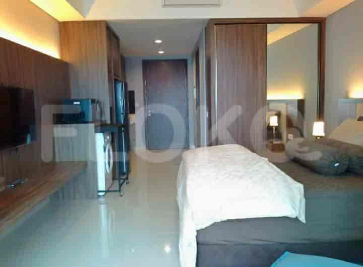 Bedroom with kitchenette including appliances, laundry, and a built-in design.