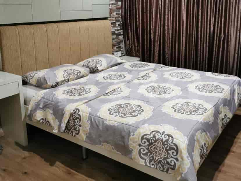 A cozy bedroom featuring a double bed with patterned bedding, and a dresser.