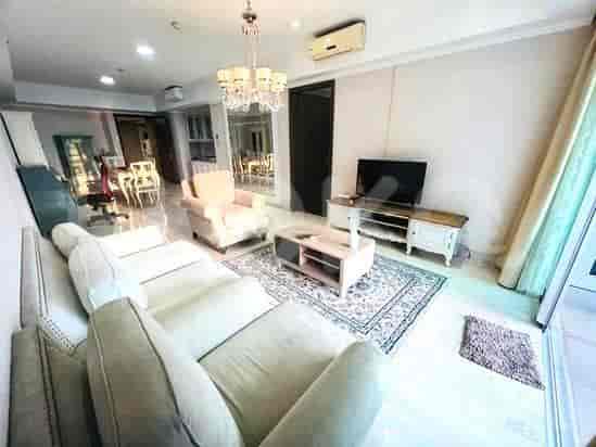 Spacious living room with a sectional sofa, TV, and dining area in the background.