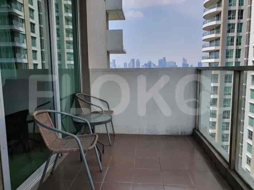 A balcony with seating and a view of the city.