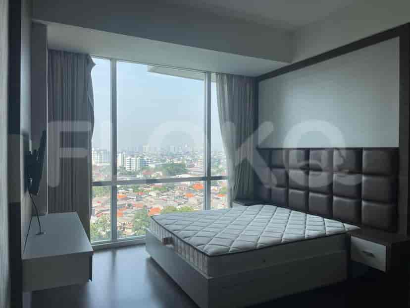 Bedroom with a bed, large window, and a TV.