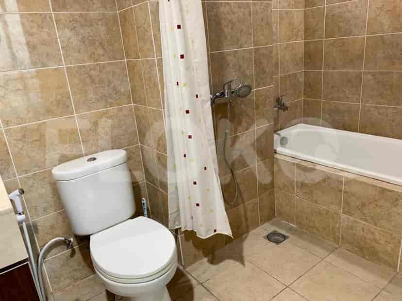 Bathroom with a white toilet, a shower with a curtain, and a bathtub.