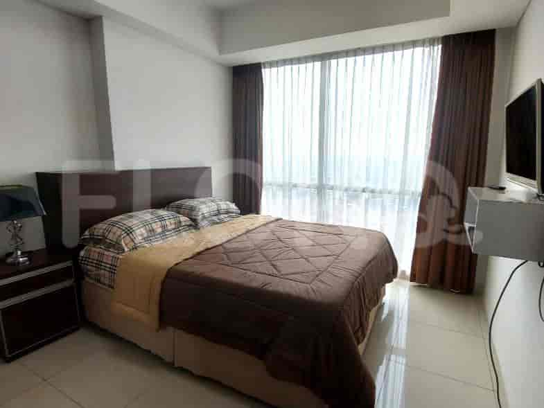 Kamar tidur dengan tempat tidur, gorden, dan TV.