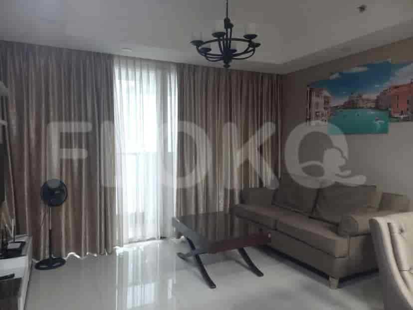 A living room with a sofa, coffee table, and curtains.