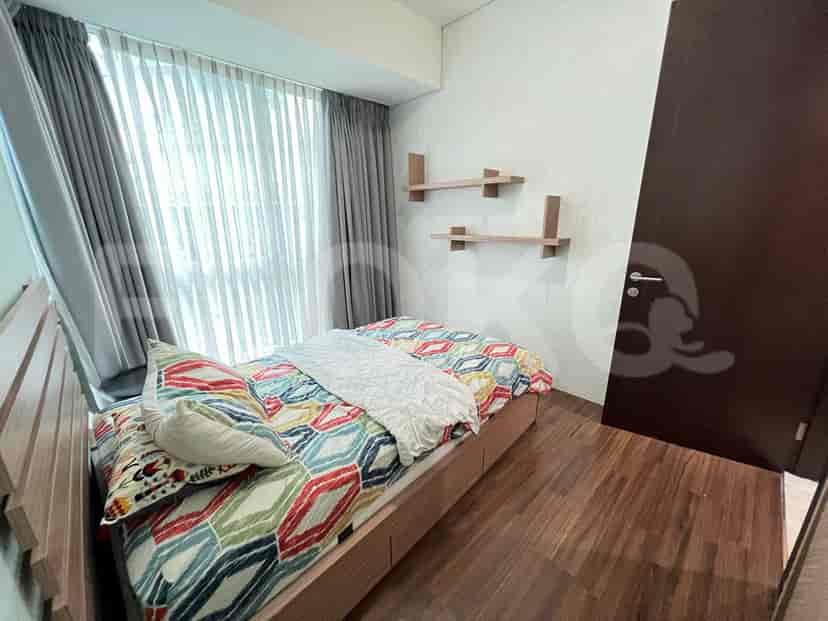 Bedroom with wooden floors and two wall shelves.