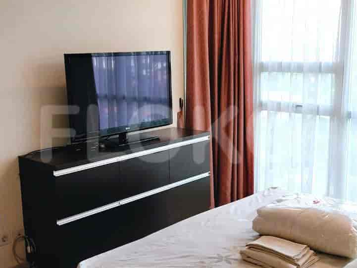 A modern bedroom with a TV, large bed, and curtains, offering a comfortable and functional space.