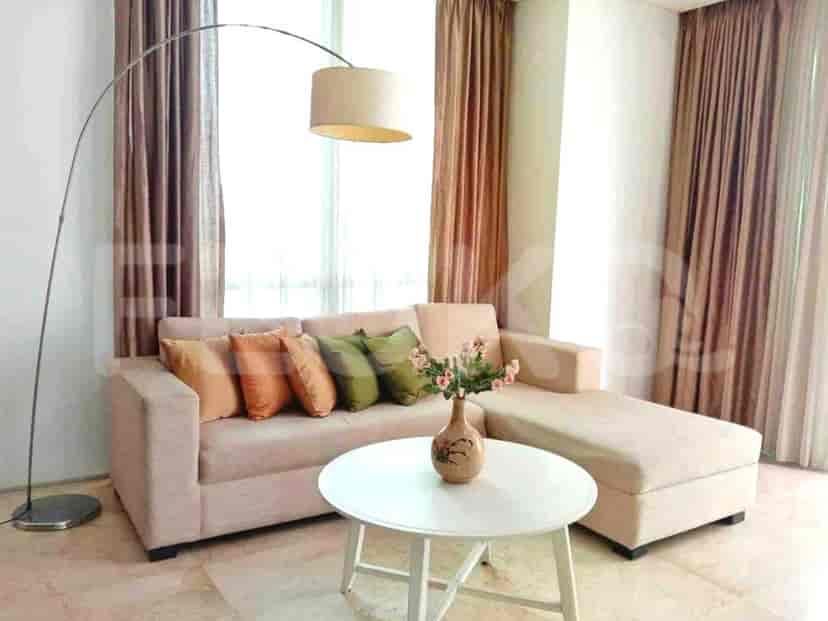 A cozy living room with an L-shaped sofa, a white table, and a large floor lamp.