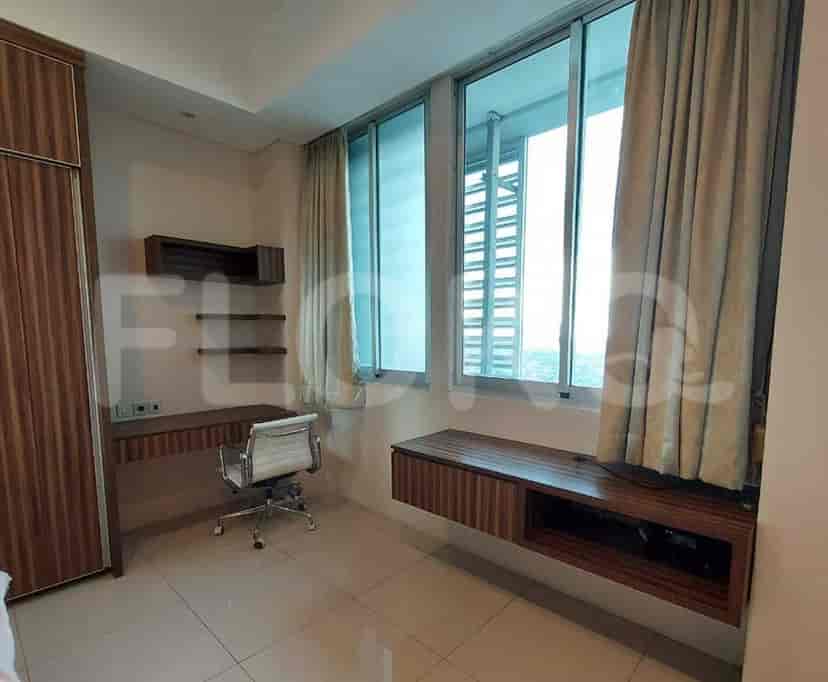 Kamar tidur yang menampilkan meja, kursi, dan jendela besar.