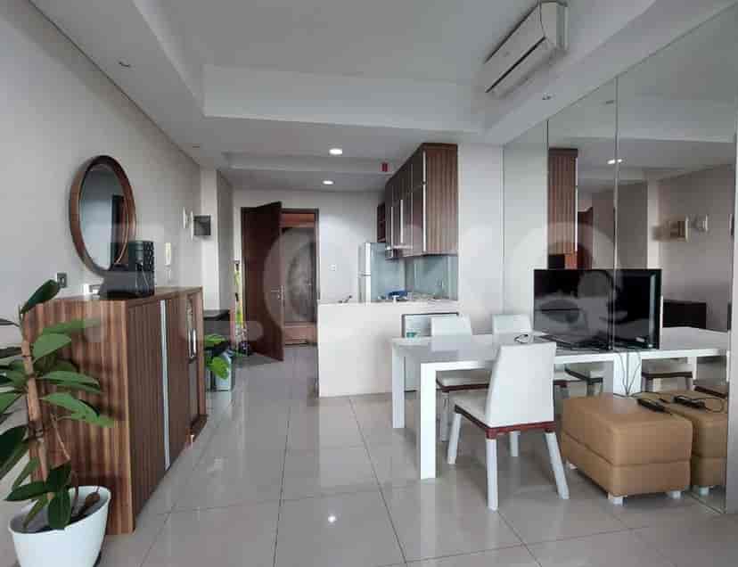 Area gabungan ruang tamu dan ruang makan dengan dapur dan jendela besar.