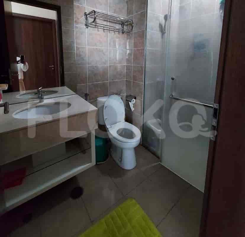 Kamar mandi yang terang dengan wastafel, toilet, dan shower.