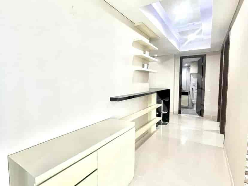 Hallway with storage cabinets and a door to the bathroom.