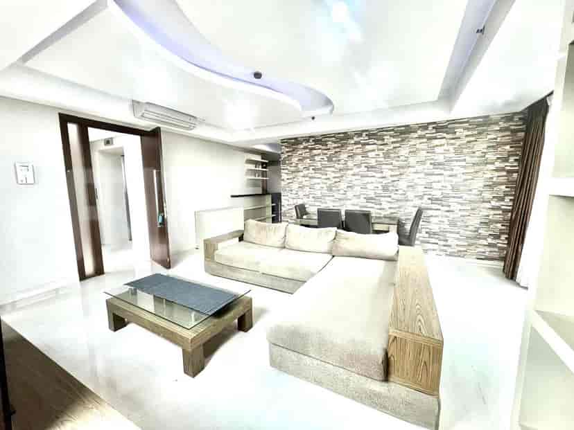 Living room with sofa, coffee table, and access to the hallway.