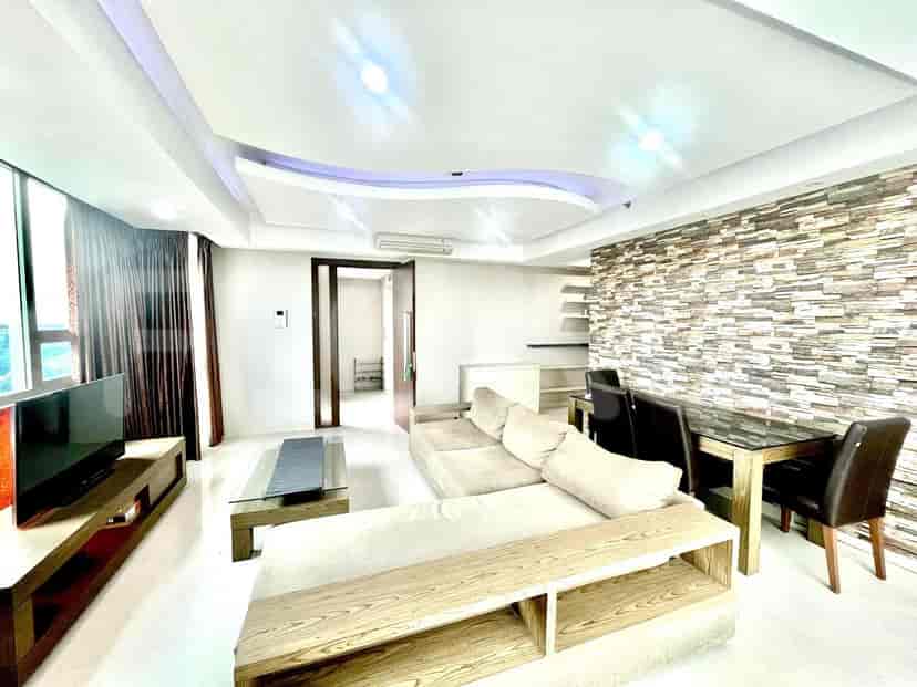 Living room with a dining area, sofa, and television.