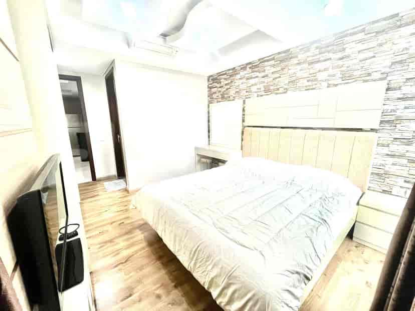 Bedroom with a double bed, dresser, and a vanity area.